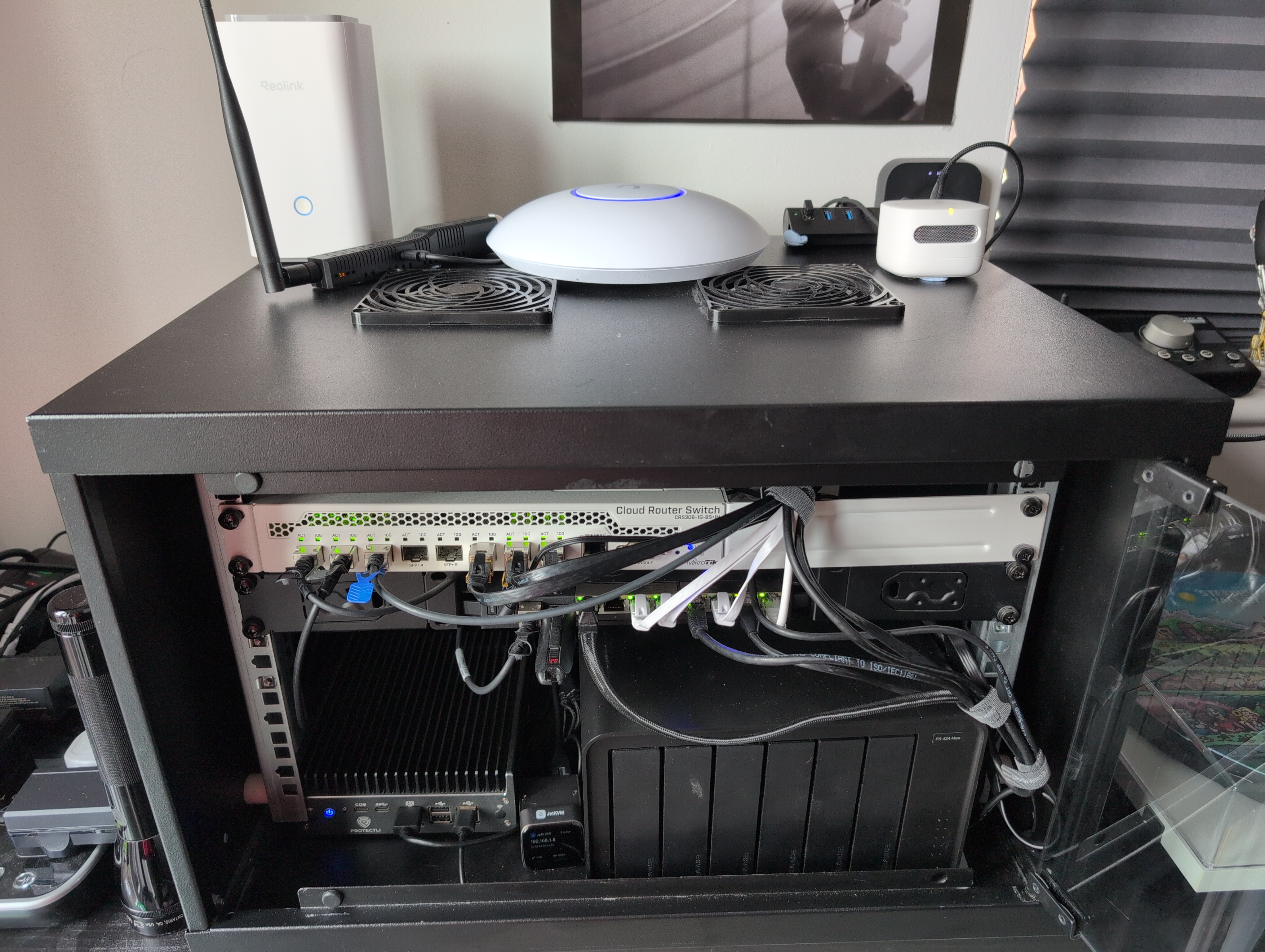 Picture of my home network cabinet, with the front windowed door open.